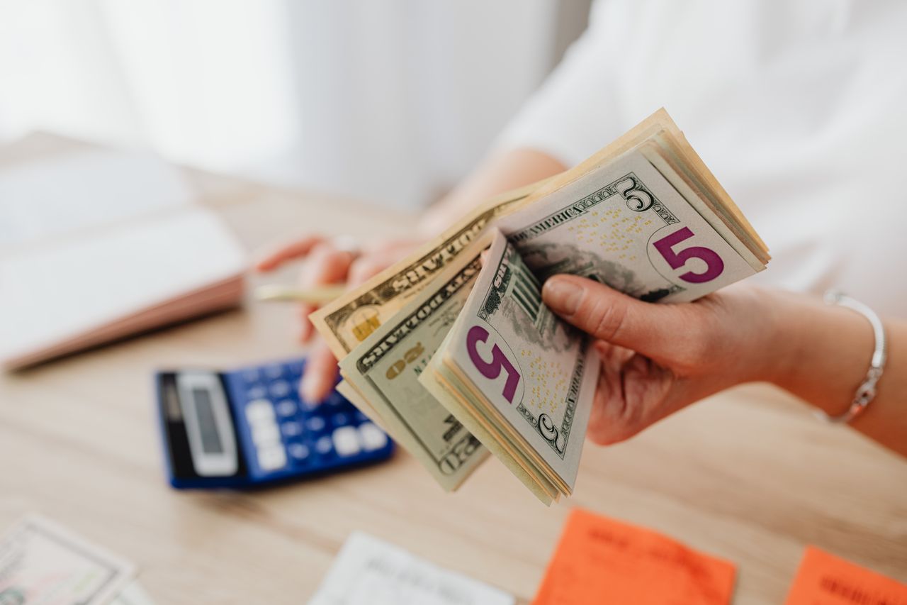 A woman holding cash and calculating