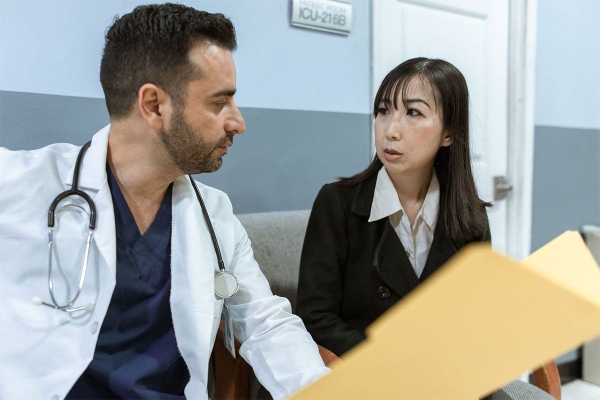 A doctor talking with an office assistant.